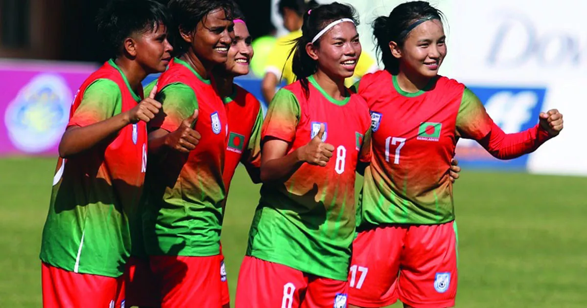 Rebel women footballers sit with head coach Peter Butler Monday