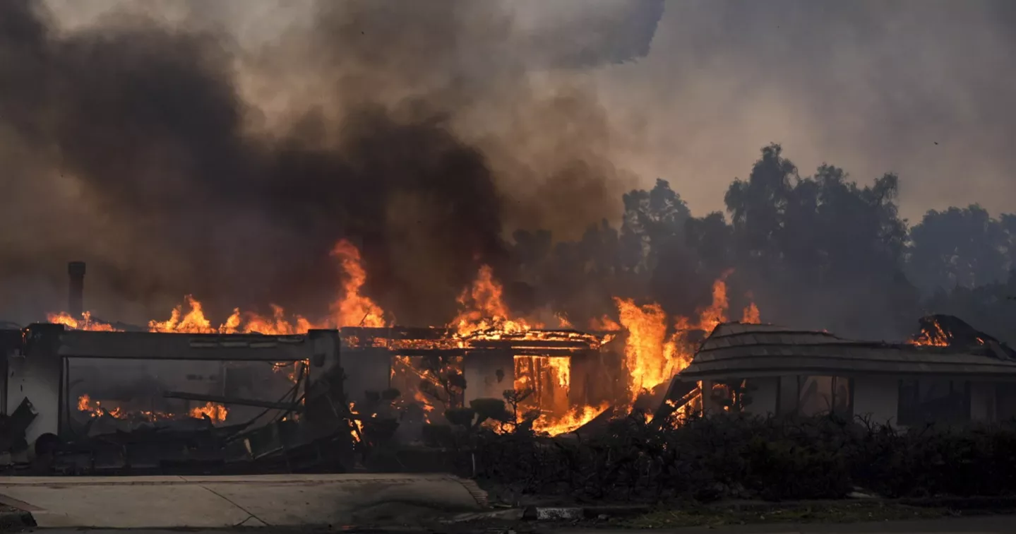 Thousands ordered to evacuate as powerful wind-fed wildfire burns homes in Southern California