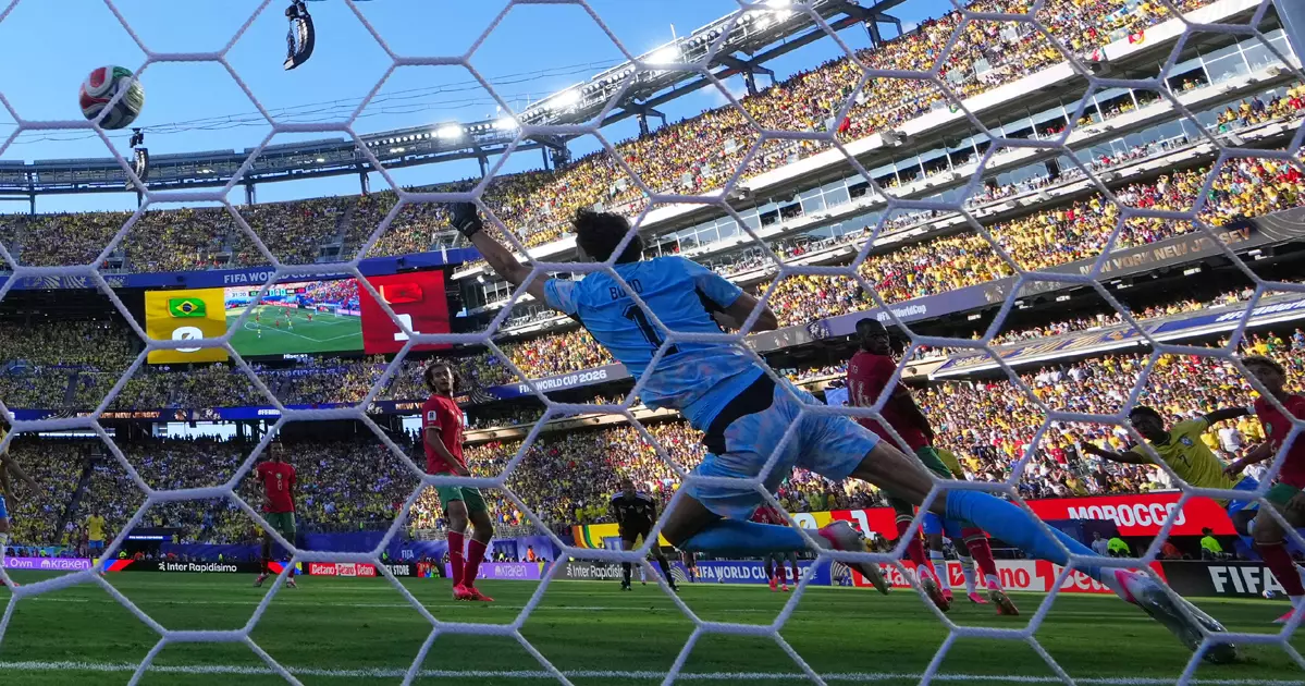 Morocco's Ismael Saibari (11) scores over Brazil goalkeeper Alisson Becker, left, as Brazil's Gabriel Magalhaes (3) and Marquinhos (4) watch during the World Cup Group C football match in East Rutherford, N.J., near New York, Saturday, June 13, 2026. (AP Photo/Matt Slocum)