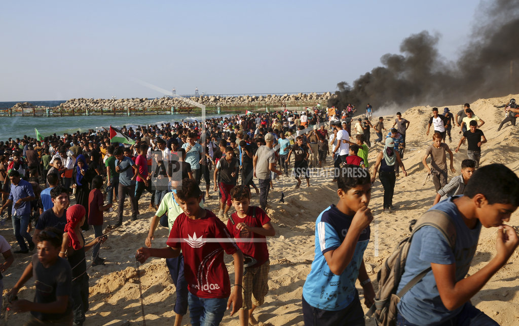 Israeli fire wounds dozens in Gaza as thousands protest